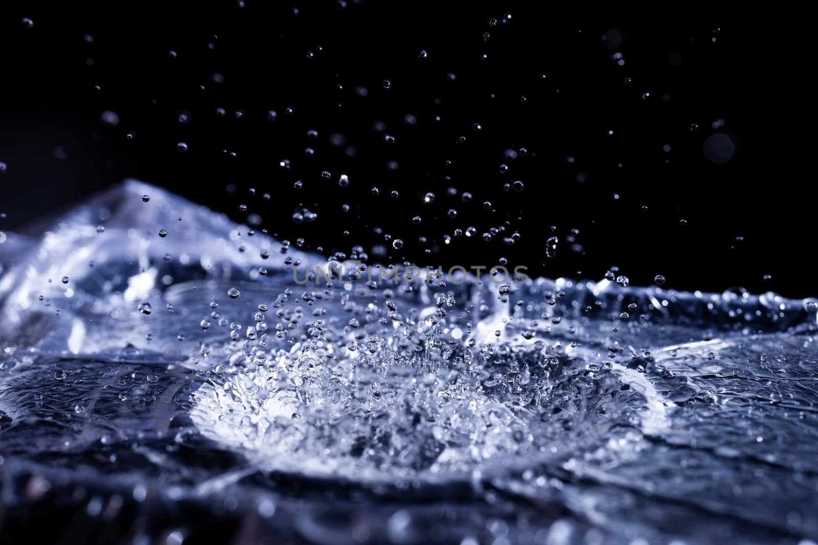 Water drops splashing on acoustic membrane. A lot of drops in air. High frequency of sound waves. Water cloud small drops. Frozen time shot.