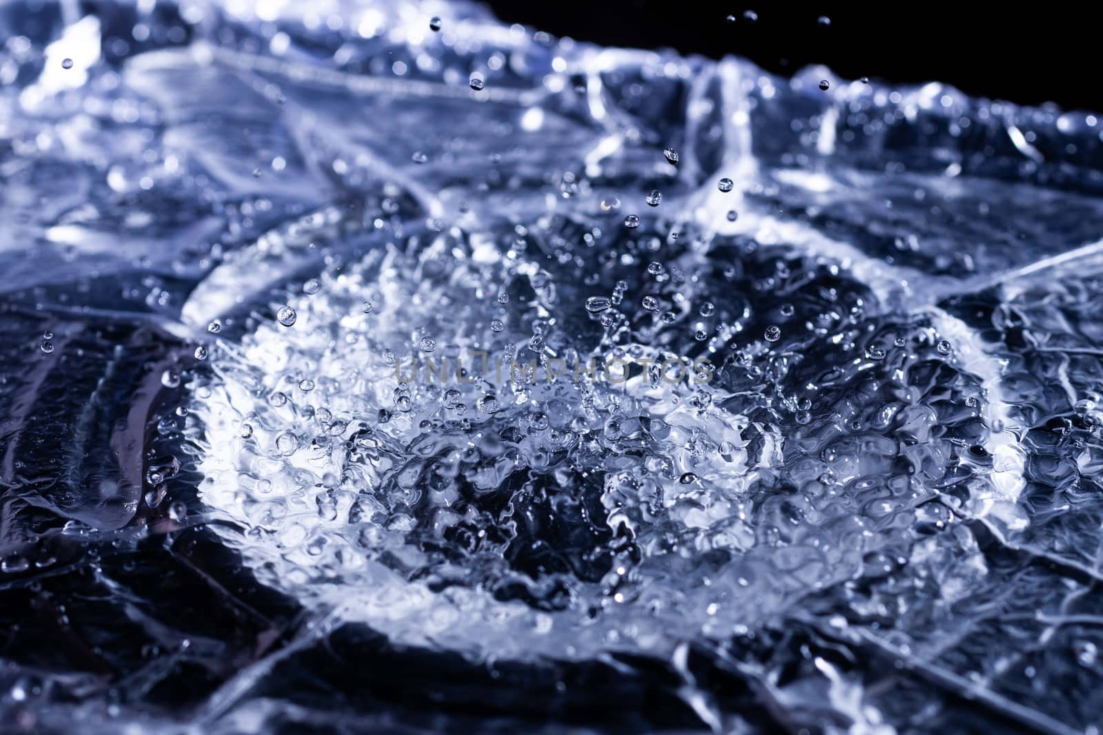 Water drops splashing on acoustic membrane. A lot of drops in air. High frequency of sound waves. Water cloud small drops. Frozen time shot.