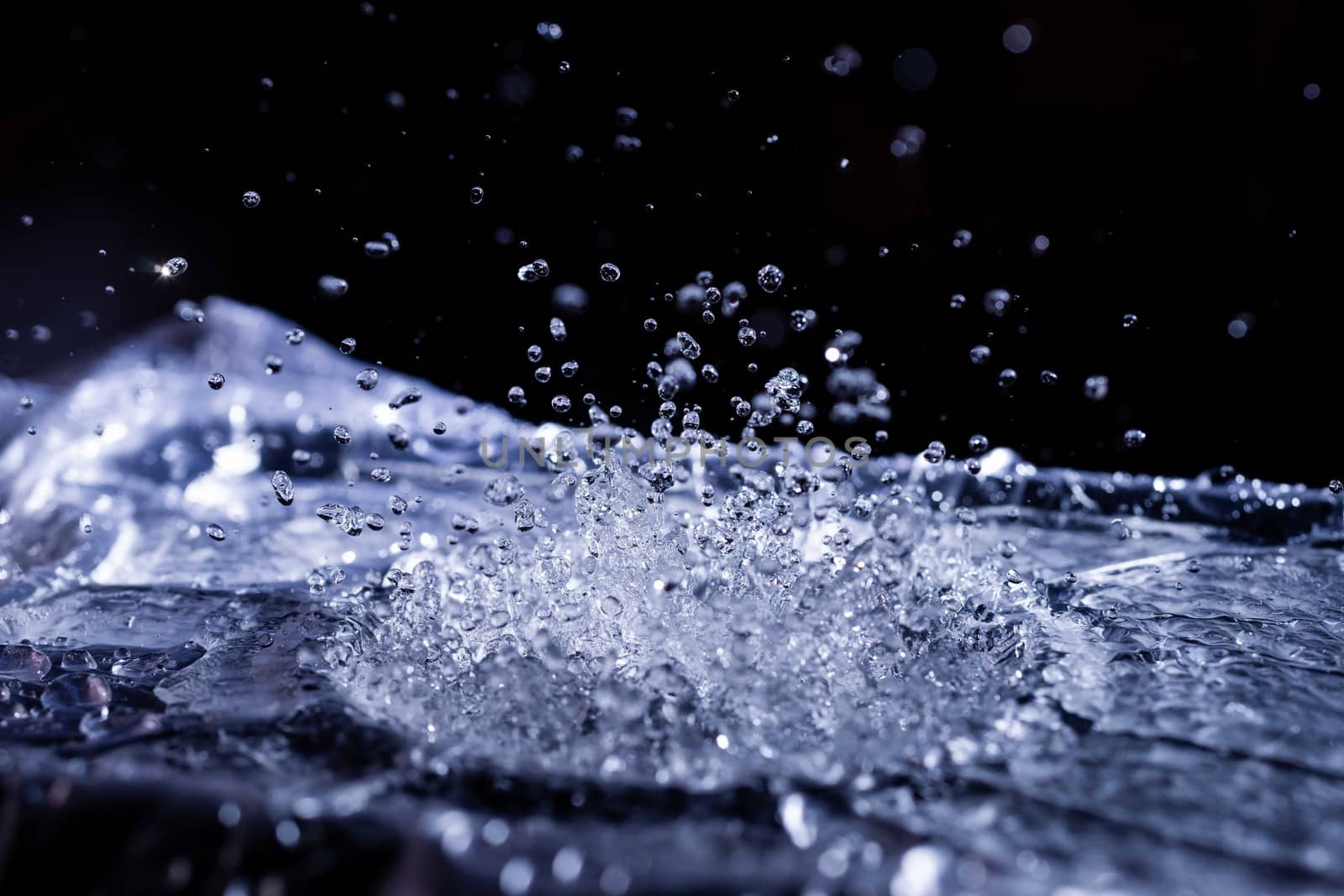 Water drops splashing on acoustic membrane. A lot of drops in air. High frequency of sound waves. Water cloud small drops. Frozen time shot.