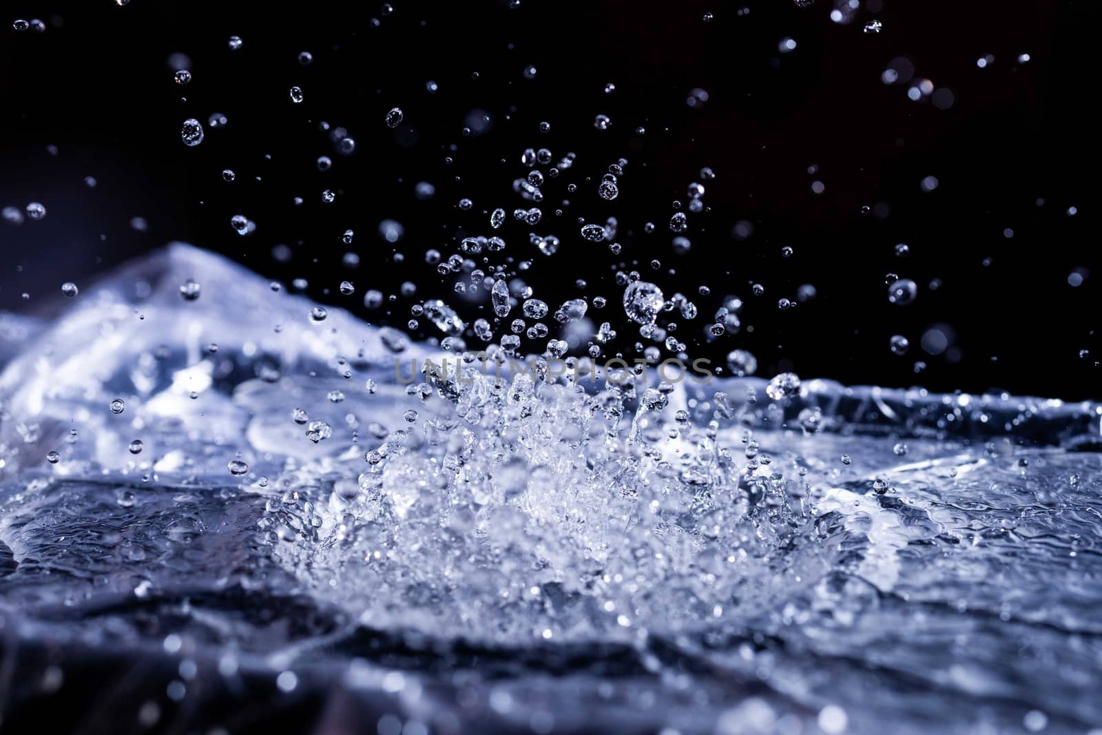 Water drops splashing on acoustic membrane. A lot of drops in air. High frequency of sound waves. Water cloud small drops. Frozen time shot.