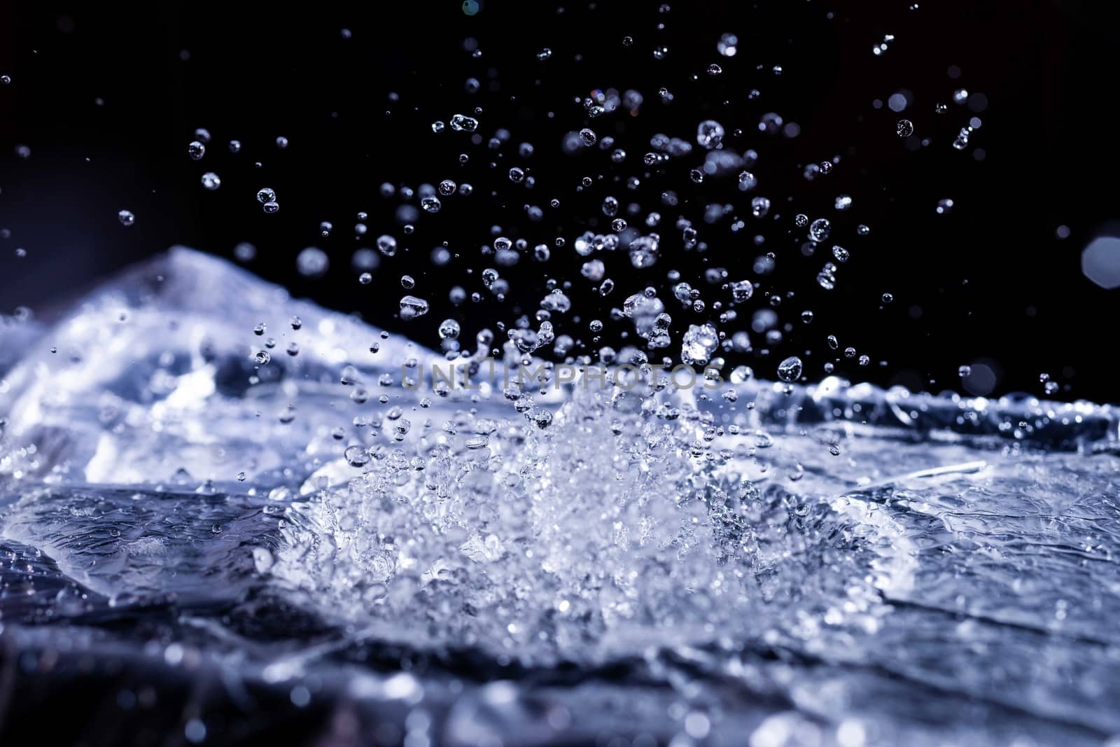 Water drops splashing on acoustic membrane. A lot of drops in air. High frequency of sound waves. Water cloud small drops. Frozen time shot.