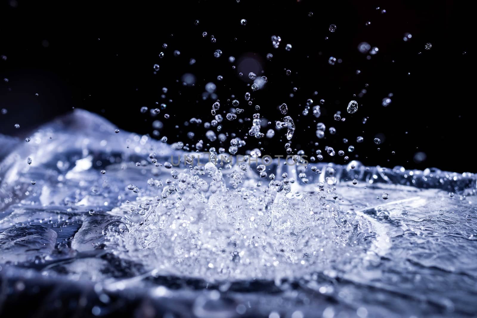 Water drops splashing on acoustic membrane. A lot of drops in air. High frequency of sound waves. Water cloud small drops. Frozen time shot.