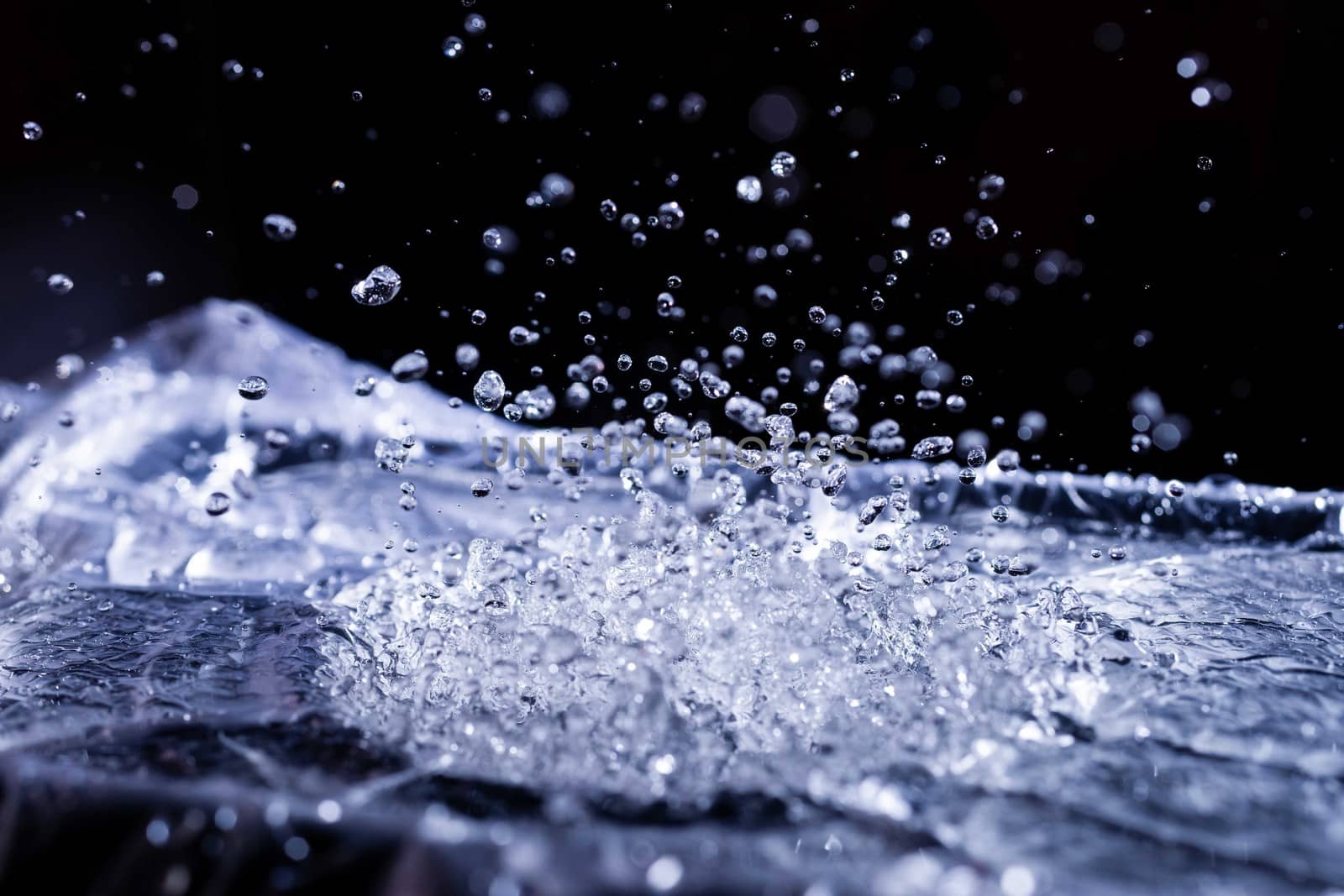 Water drops splashing on acoustic membrane. A lot of drops in air. High frequency of sound waves. Water cloud small drops. Frozen time shot.