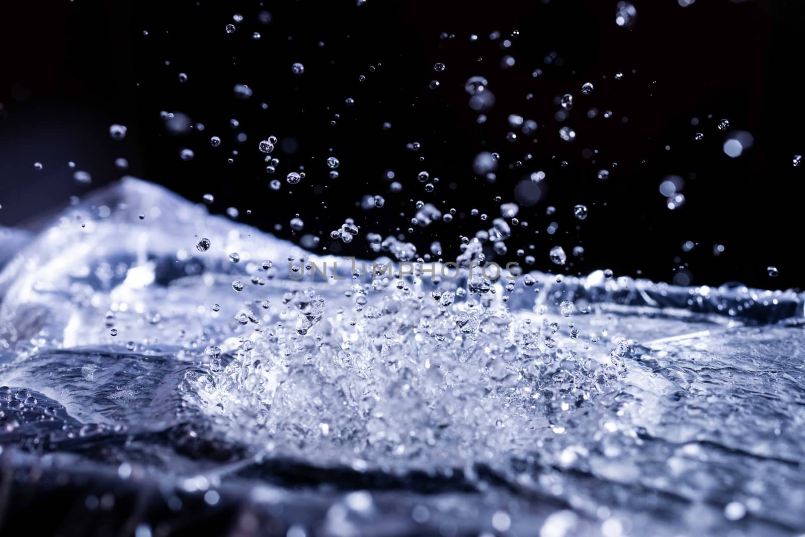 Water drops splashing on acoustic membrane. A lot of drops in air. High frequency of sound waves. Water cloud small drops. Frozen time shot.