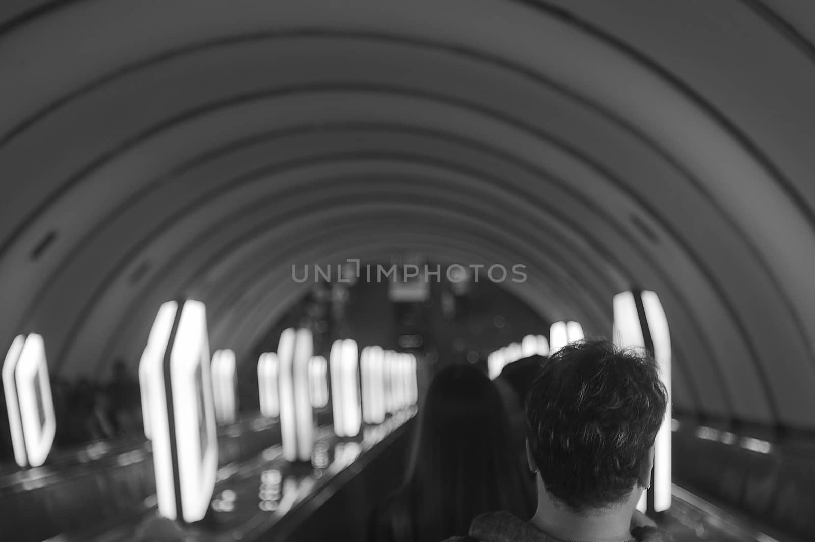 the man on the escalator turned his back. Black and white photos, the lamps are arranged in rows. Photo shows loneliness in society