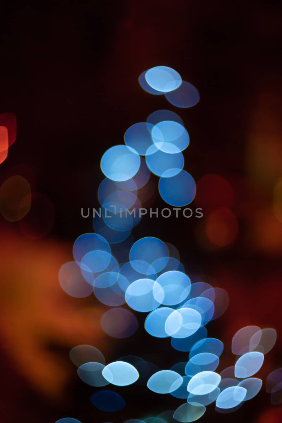 Outdoor Christmas tree defocused light. White lights in tree is blurred. Big beautiful curly bokeh