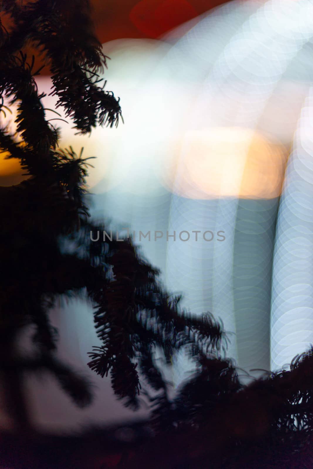 Christmas tree in focus in foreground. Christmas garland on blurred background. Light is light and defocused. Blurred background, new year mood.