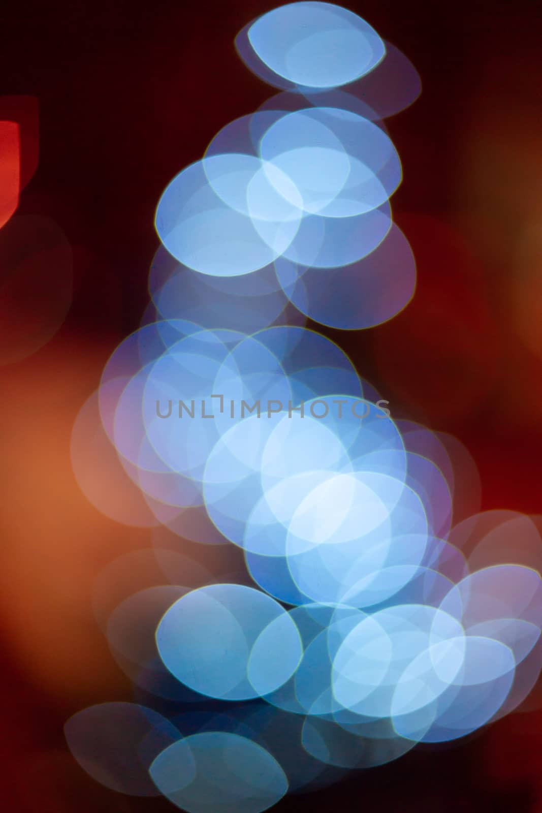 Outdoor Christmas tree defocused light. White lights in tree is blurred. Big beautiful curly bokeh