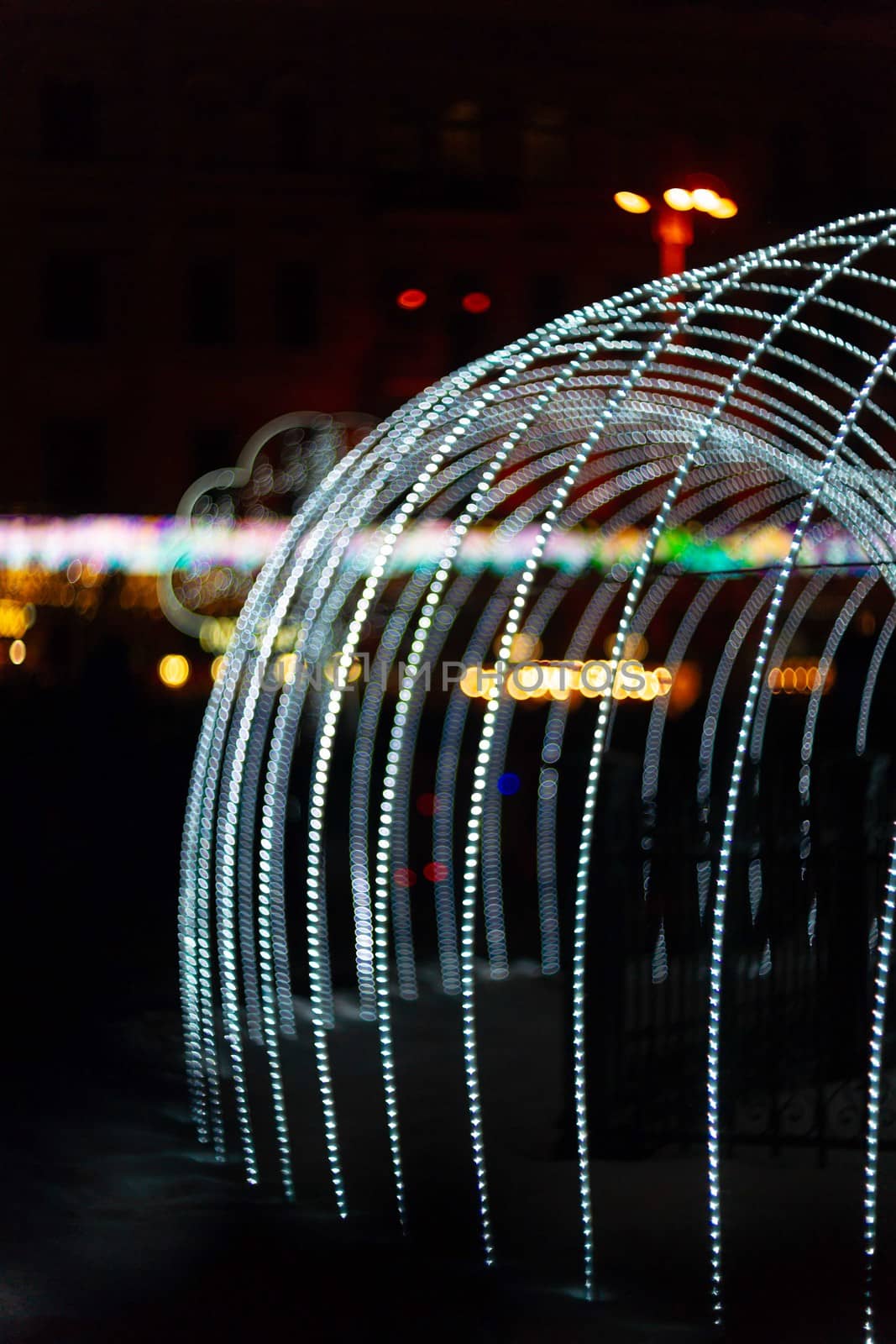 Vertical Christmas garland wall. Light is white and defocused. Blurred background, new year mood.