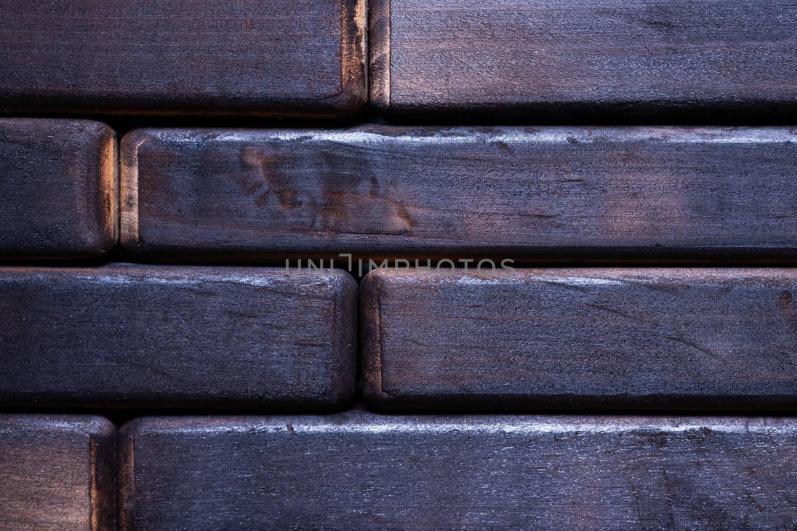 Dark black wooden background. Floor contains wooden bricks. Closeup view.