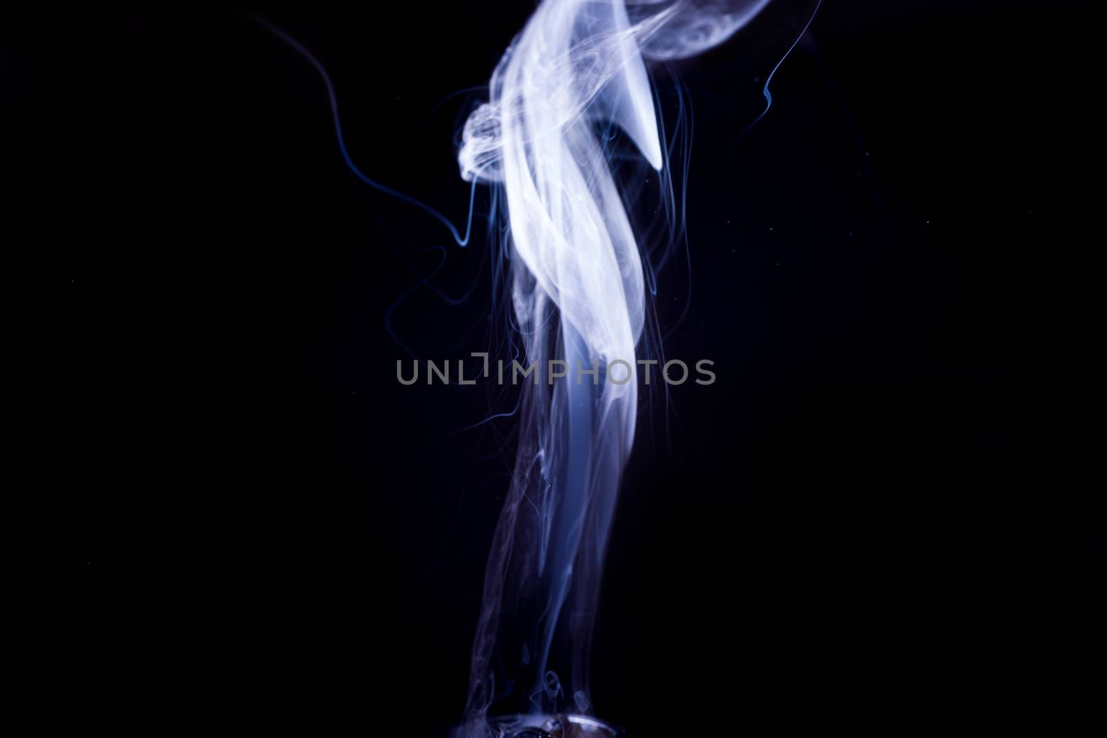 Vape smoke clouds isolated on black background. Hot vape liquid splash in vape coil. Nice aromatic cloud. Low light photo. Underexposed photo in a low key style.