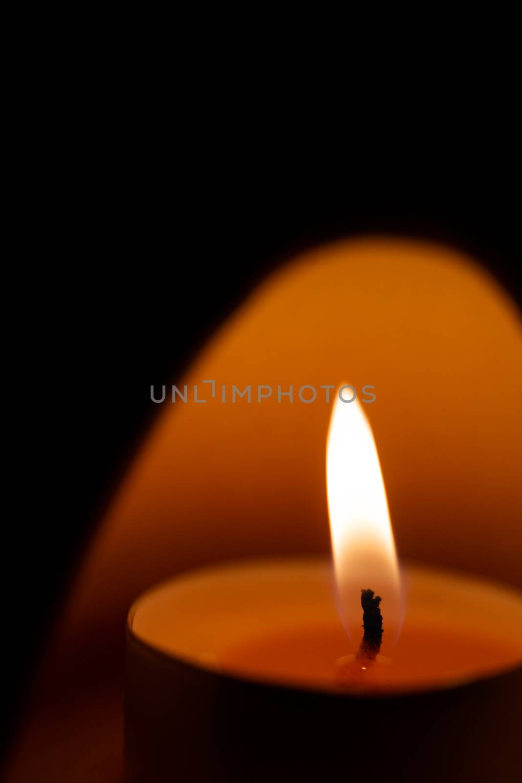 Underexposed low light photo of candle in aromatic lamp. Close-up view