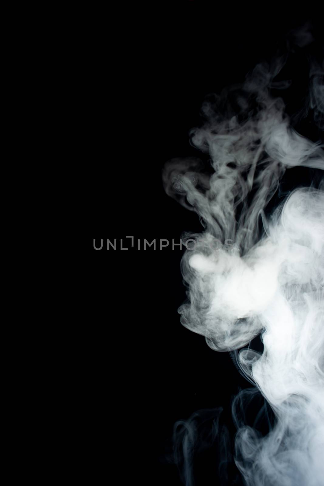 Сlouds of vape fog on black background. At right side thick smoke rising up. Vape culture and no smoking movement.