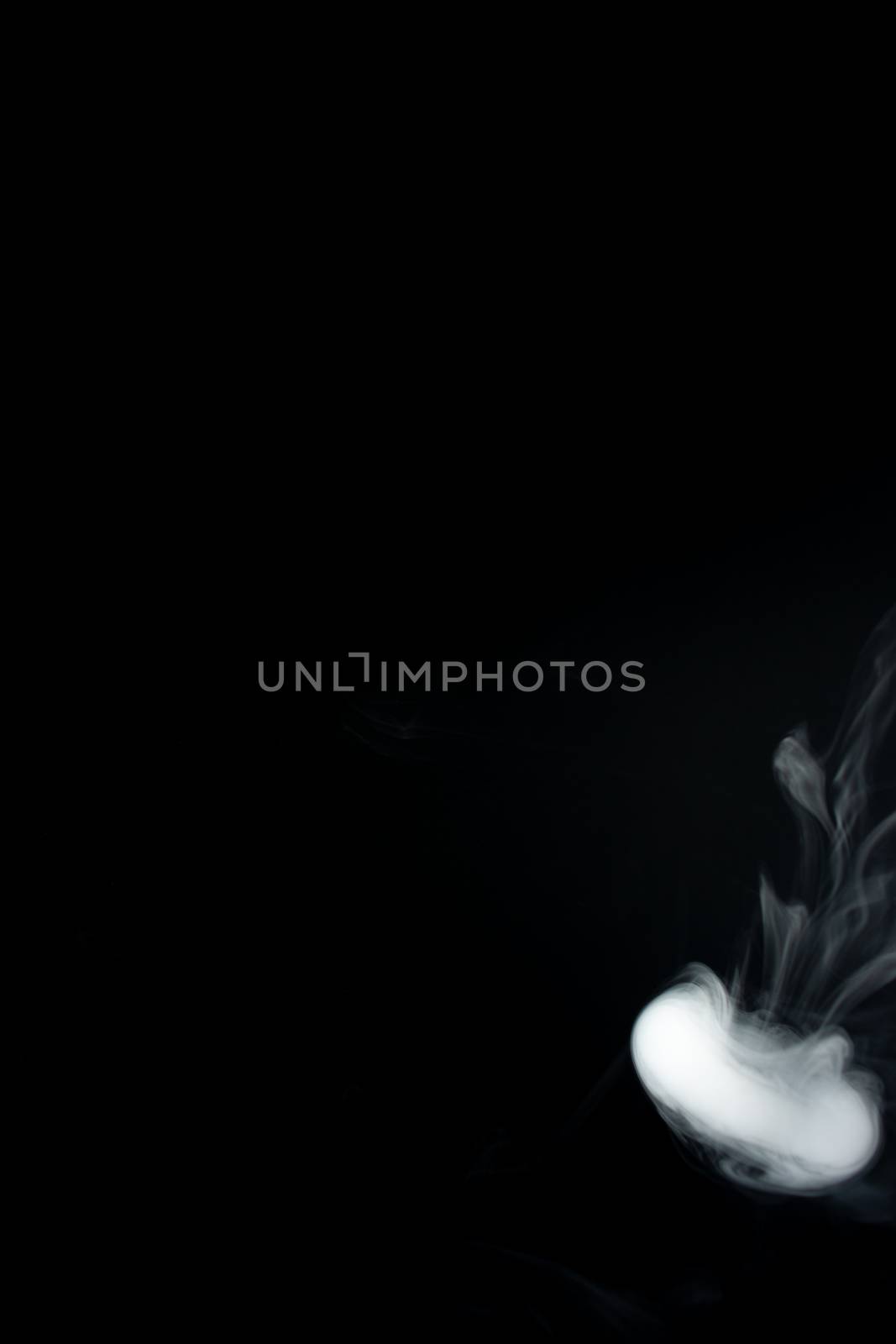 Round ring of vape fog on black background. At right side thick smoke ring goes down.. Vape culture and no smoking direction.