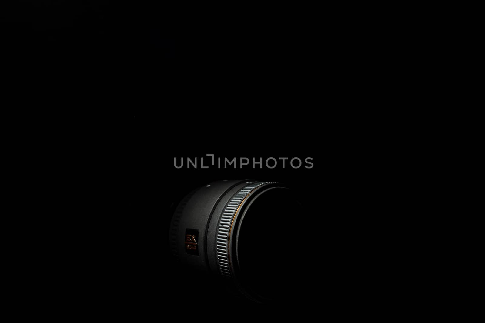 Ukraine; Kyiv; 20.02.2019 Sigma 50mm f1:2,8 DG EX Macro lens. Underexposed photo of DSLR camera lens on black background. Stock photo isolated. Low light photo and large depth of field.