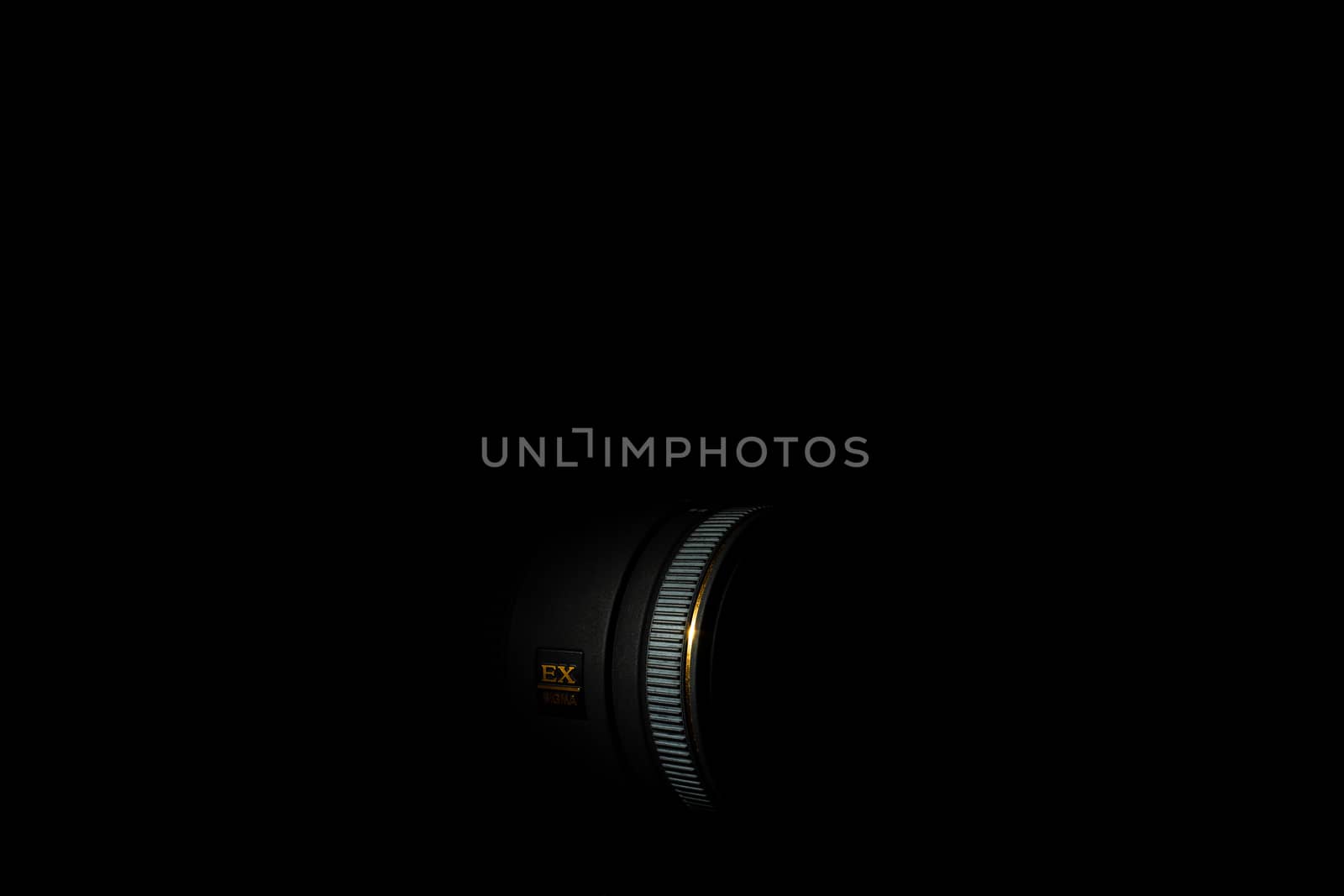 Ukraine; Kyiv; 20.02.2019 Sigma 50mm f1:2,8 DG EX Macro lens. Underexposed photo of DSLR camera lens on black background. Stock photo isolated. Low light photo and large depth of field.