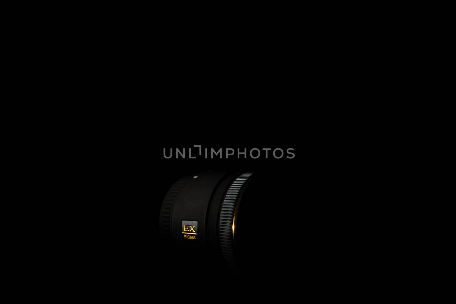 Ukraine; Kyiv; 20.02.2019 Sigma 50mm f1:2,8 DG EX Macro lens. Underexposed photo of DSLR camera lens on black background. Stock photo isolated. Low light photo and large depth of field.
