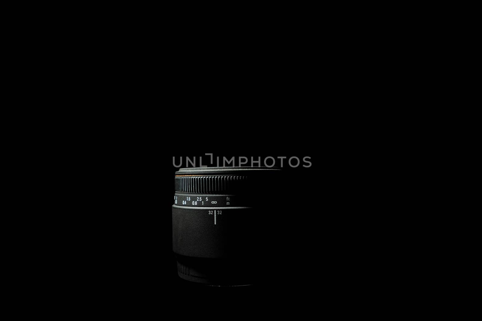 Underexposed photo of DSLR camera lens lying on black background. Stock photo isolated. Low light photo and large depth of field.