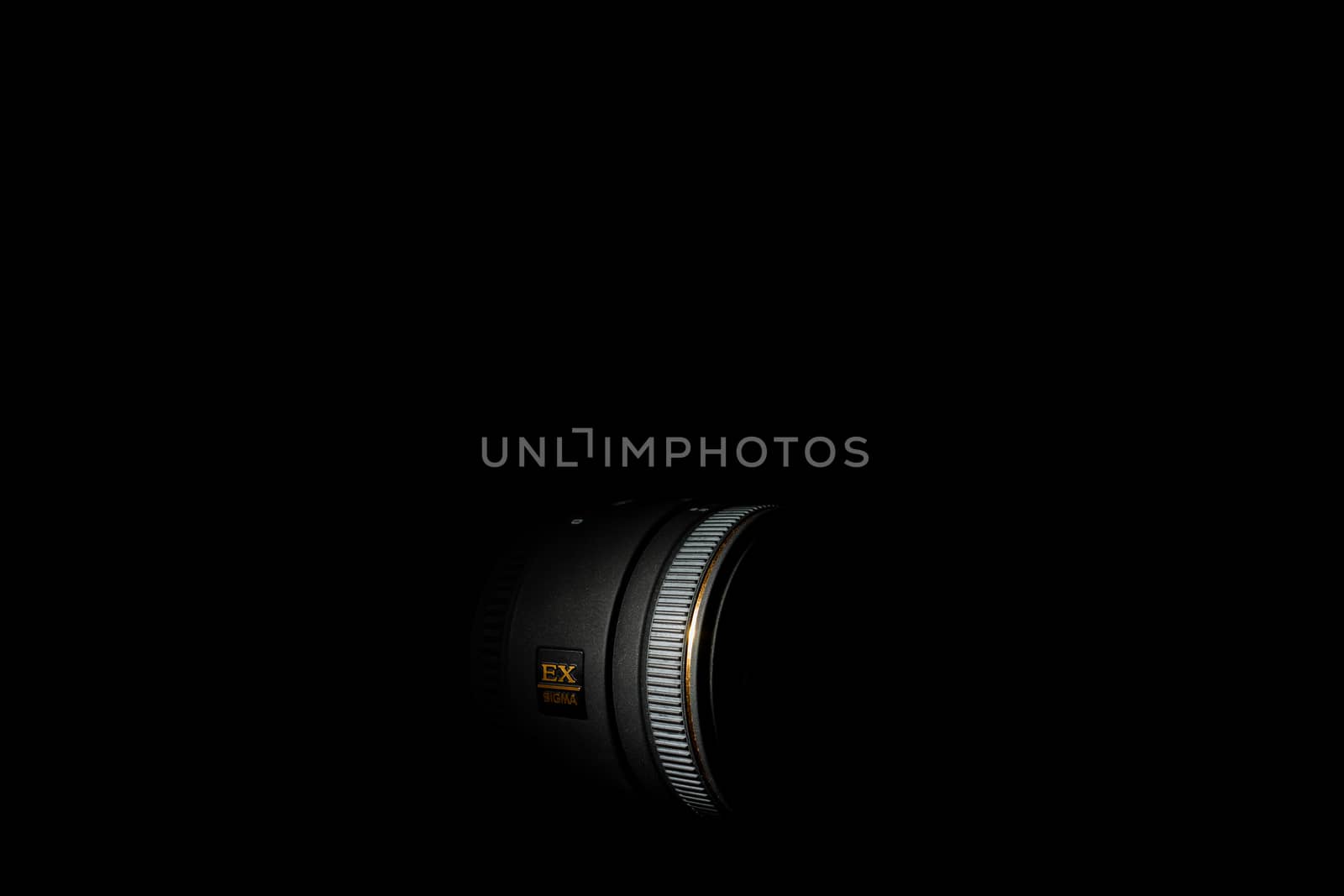 Ukraine; Kyiv; 20.02.2019 Sigma 50mm f1:2,8 DG EX Macro lens. Underexposed photo of DSLR camera lens on black background. Stock photo isolated. Low light photo and large depth of field.