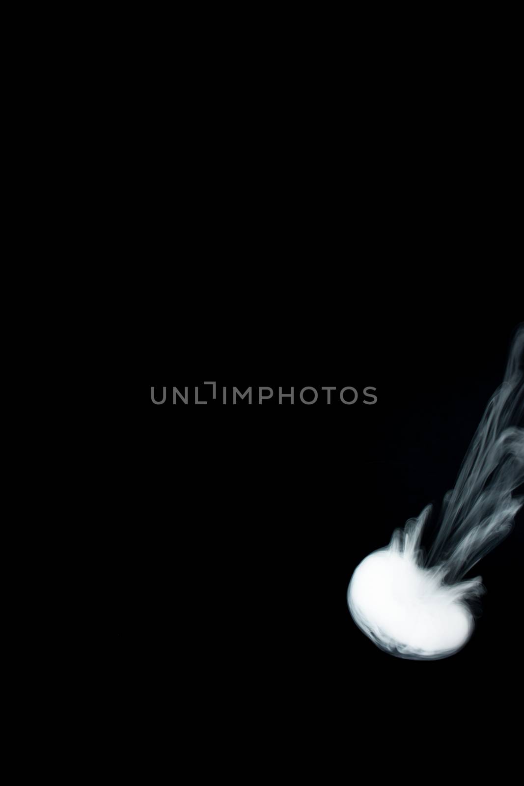 Round ring of vape fog on black background. At right side thick smoke ring goes down.. Vape culture and no smoking direction.
