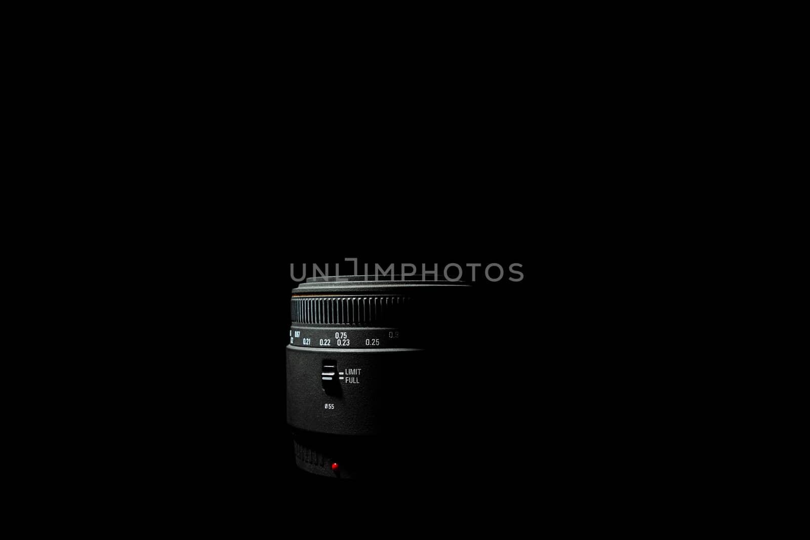 Underexposed photo of DSLR camera lens lying on black background. Stock photo isolated. Low light photo and large depth of field.