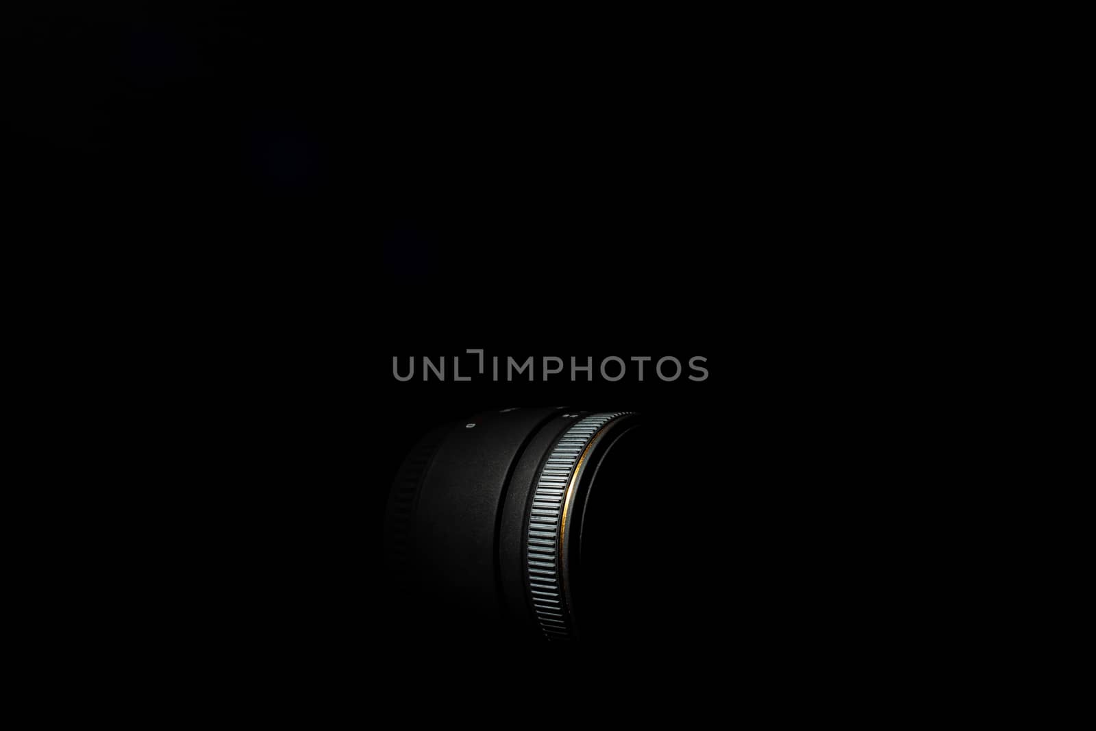 Underexposed photo of DSLR lens. Stock photo isolated on black background. Low light photo. A large depth of field.
