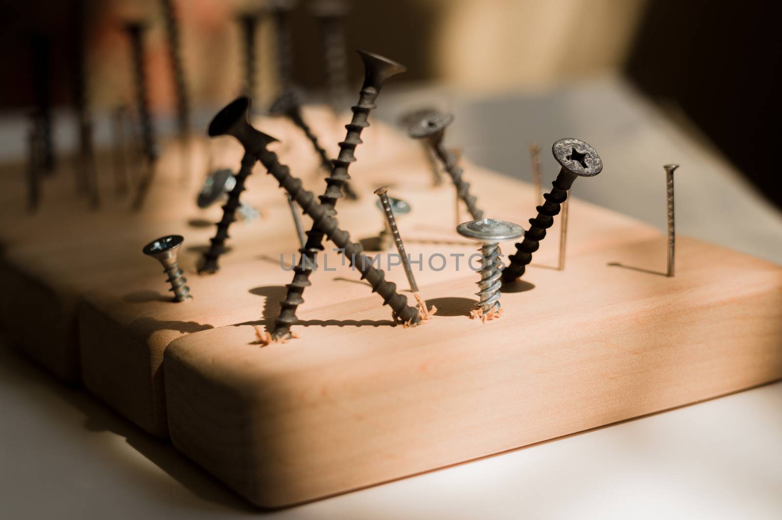 Learn the work with a screwdriver. Teaching to use tools. Conceptual photo. Learning to use screwdriver and a hammer. Many screws and pins.