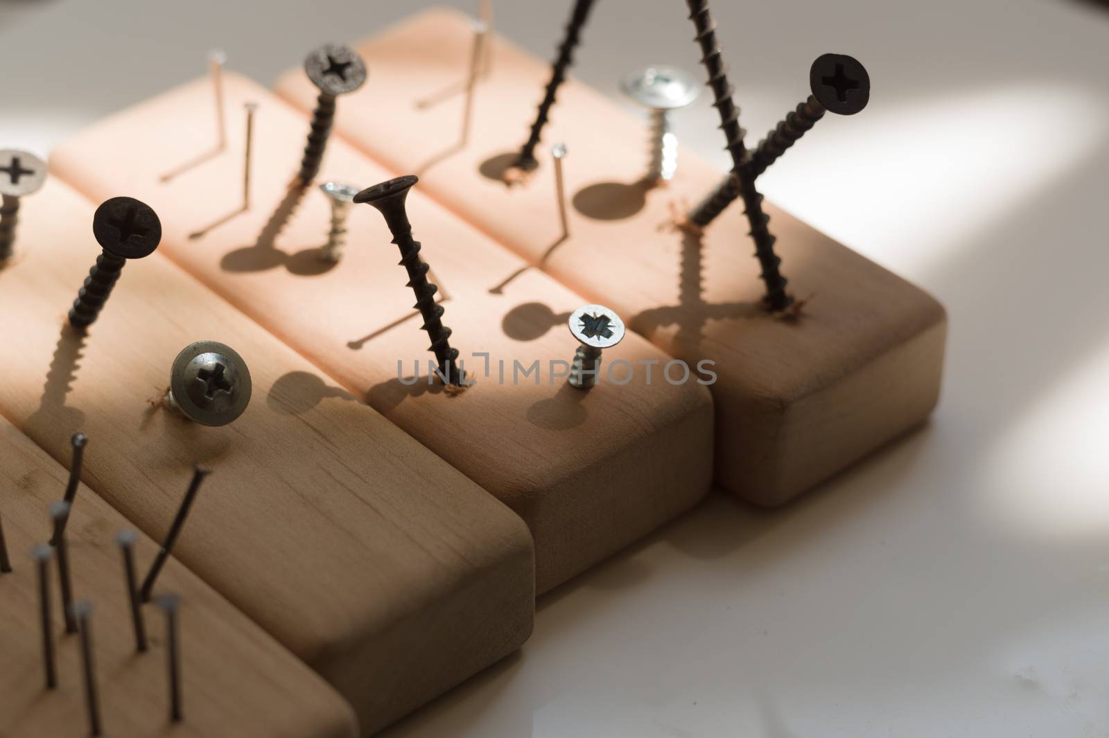 Learn the work with a screwdriver. Teaching to use tools. Conceptual photo. Learning to use screwdriver and a hammer. Many screws and pins.