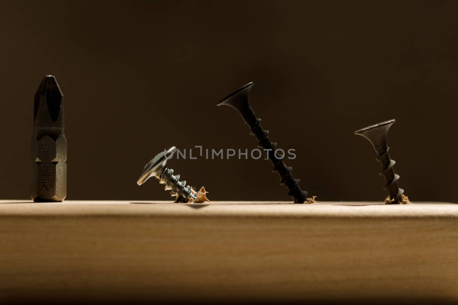Learn the work with a screwdriver. Teaching to use tools. Conceptual photo. Bit for screwdriver and three screws- one silver and two black.