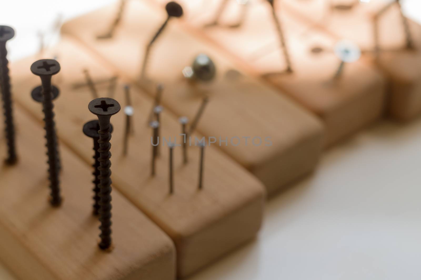 Learn the work with a screwdriver. Teaching to use tools. Conceptual photo. Learning to use screwdriver and a hammer. Many screws and pins.
