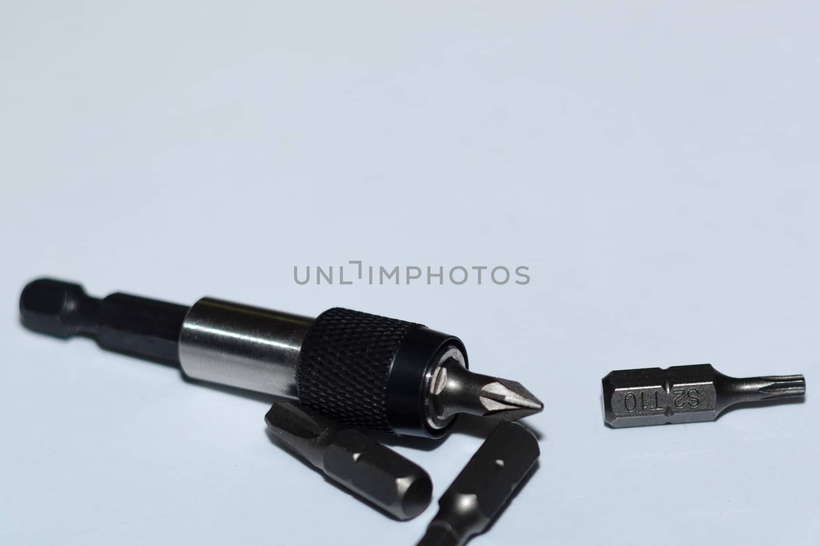 Many tool bits with bitholder on white background.