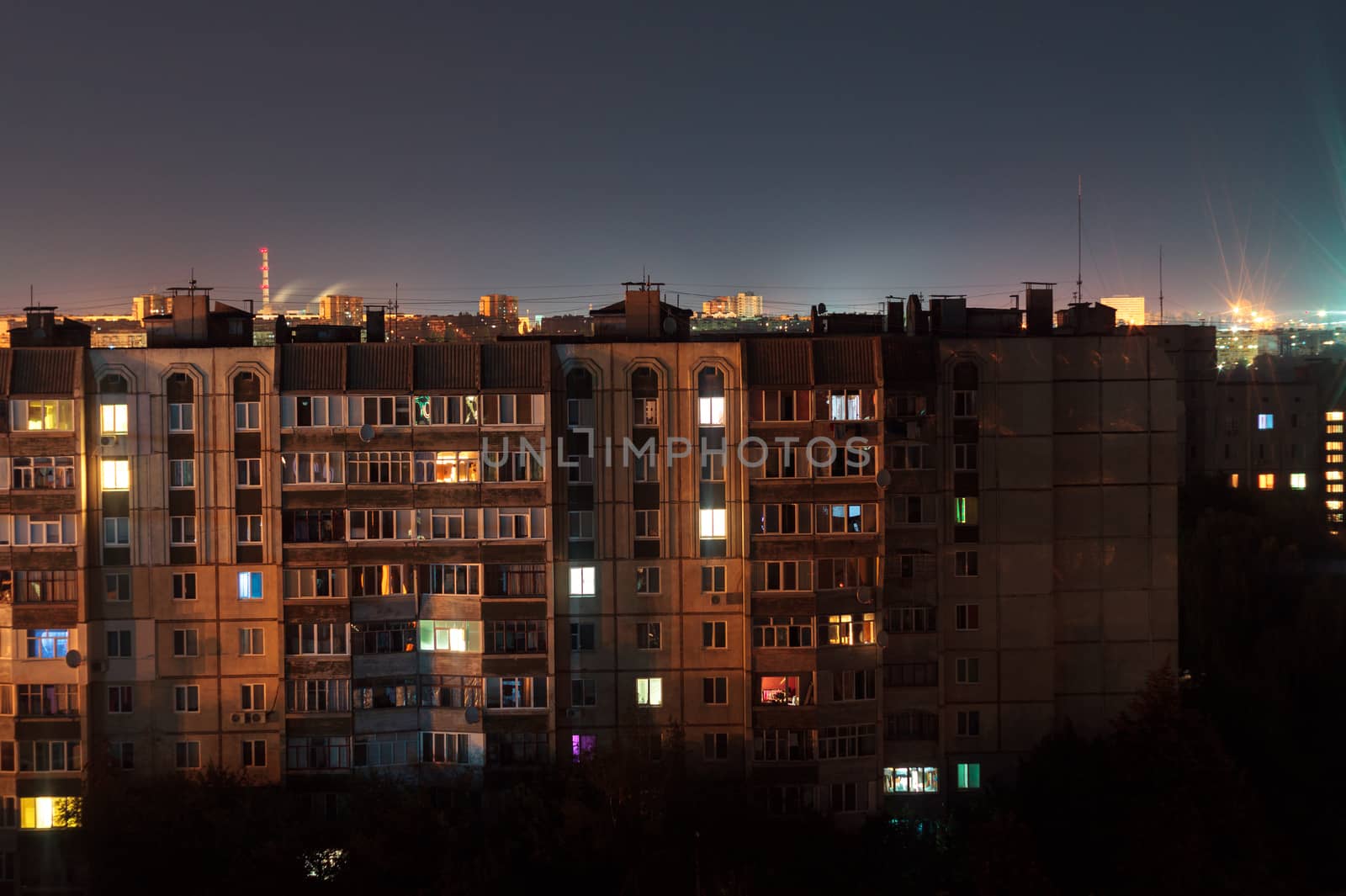 Night long exposure photo 9 and 10 floors high-rise buildings in orange colours. Big city life is here!