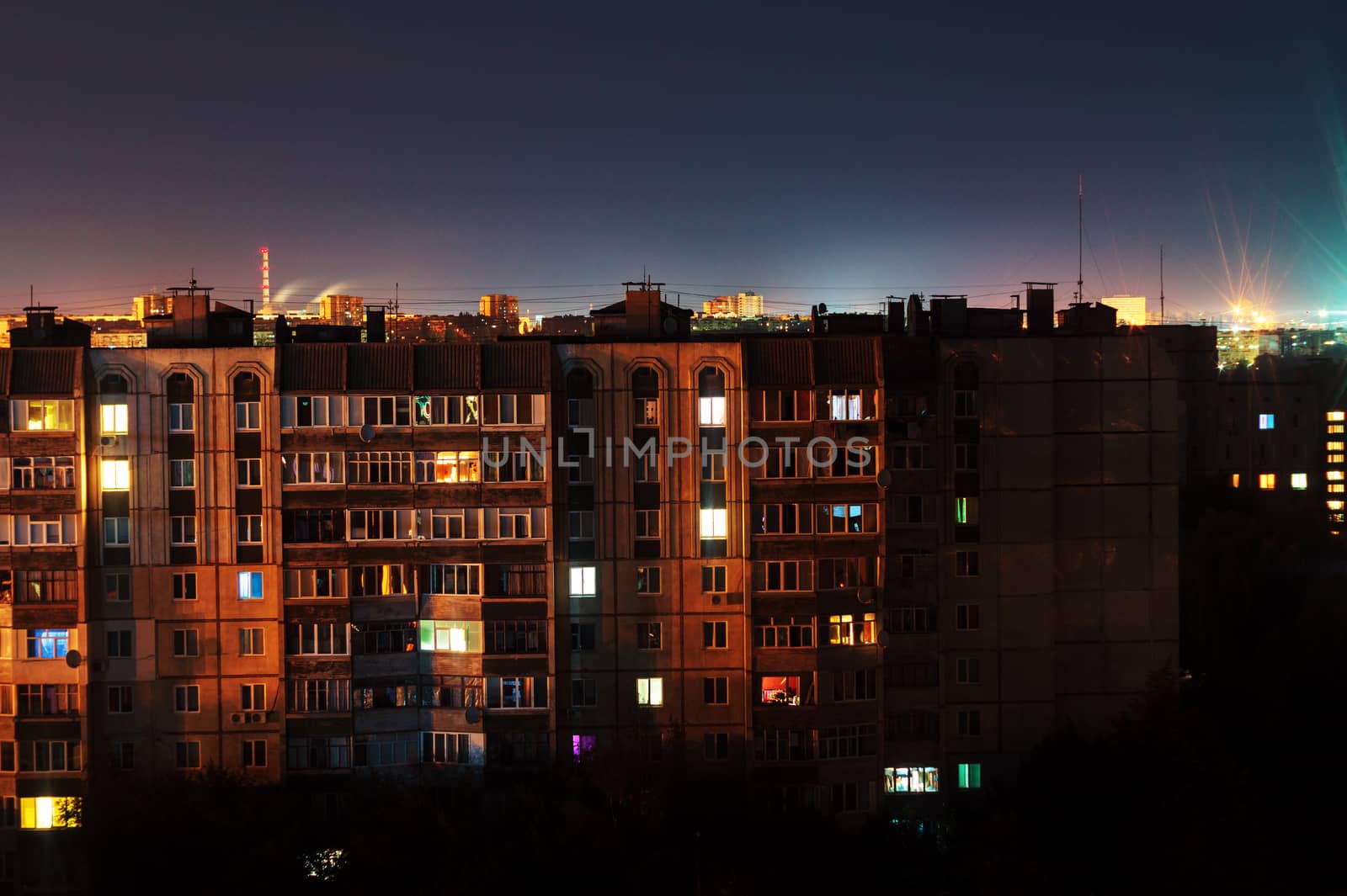 Night long exposure photo 9 and 10 floors high-rise buildings in orange colours. Big city life is here!