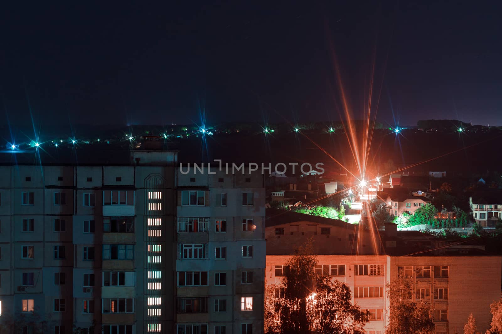 Night long exposure photo 9 and 10 floors high-rise buildings in blue and red colours. Big city life is here!