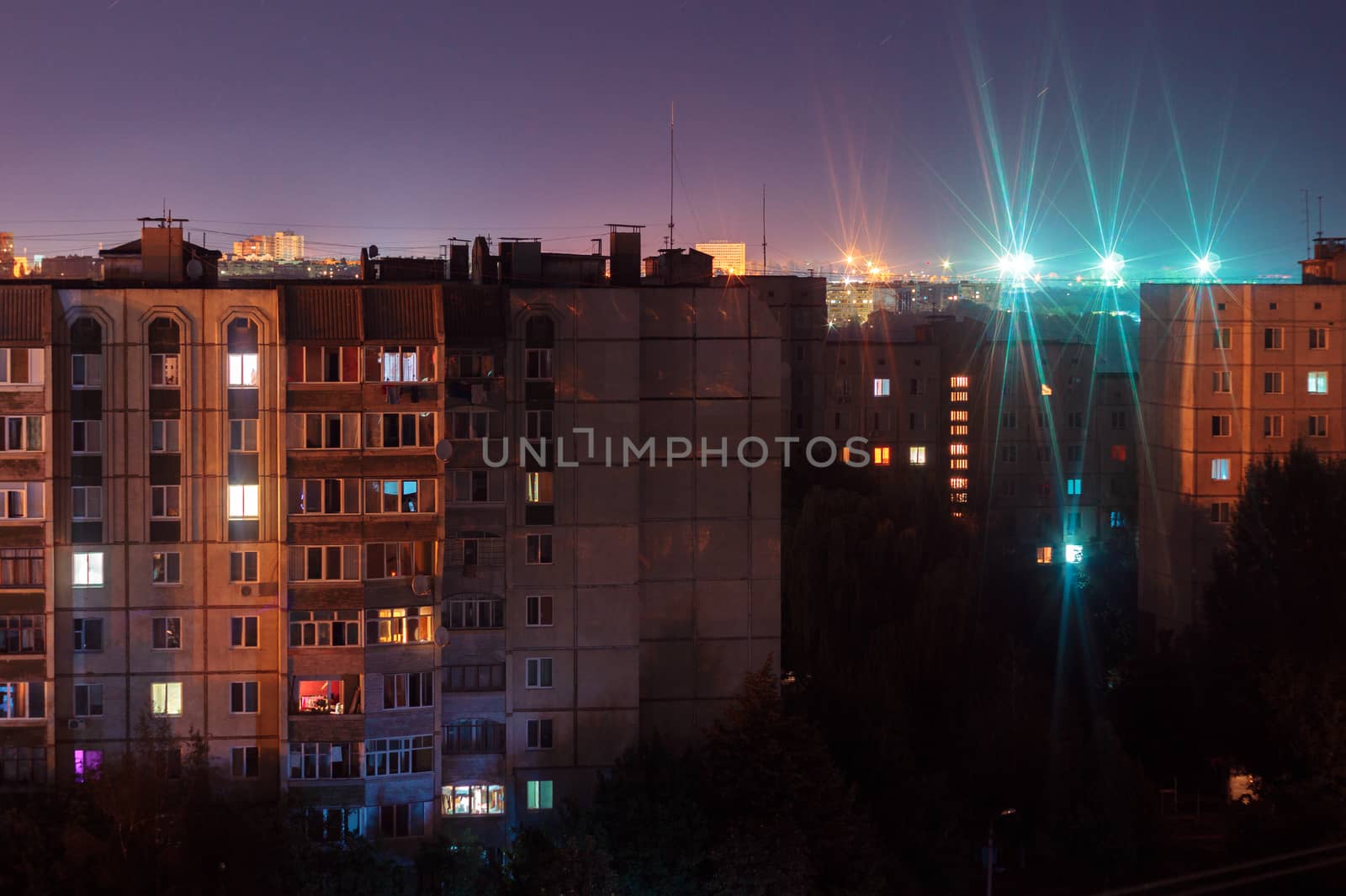 Night long exposure photo 9 and 10 floors high-rise buildings in orange and blue colours. Big city life is here!