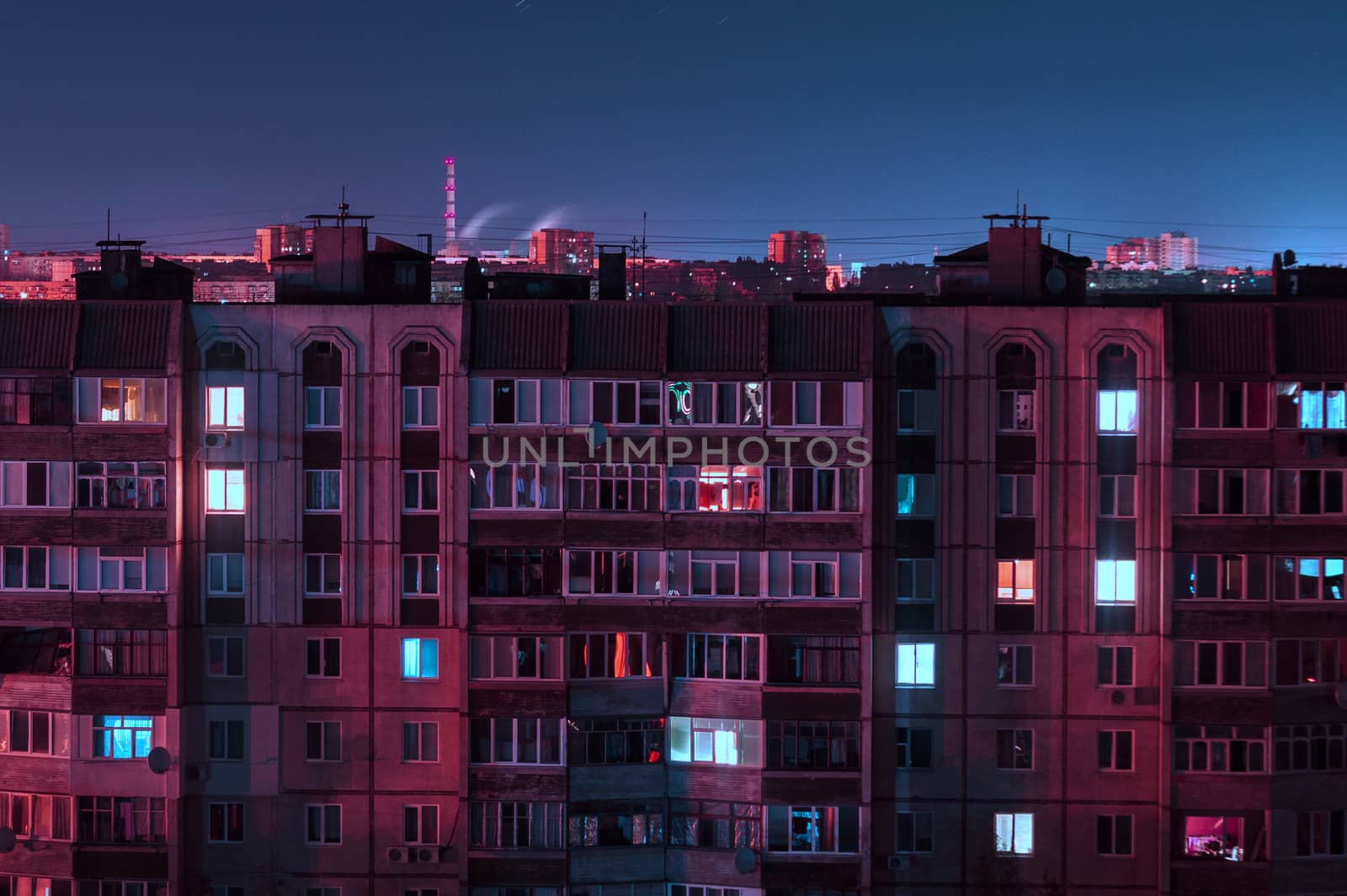 Night long exposure photo 9 and 10 floors high-rise buildings in purple colors. Big city life is here!