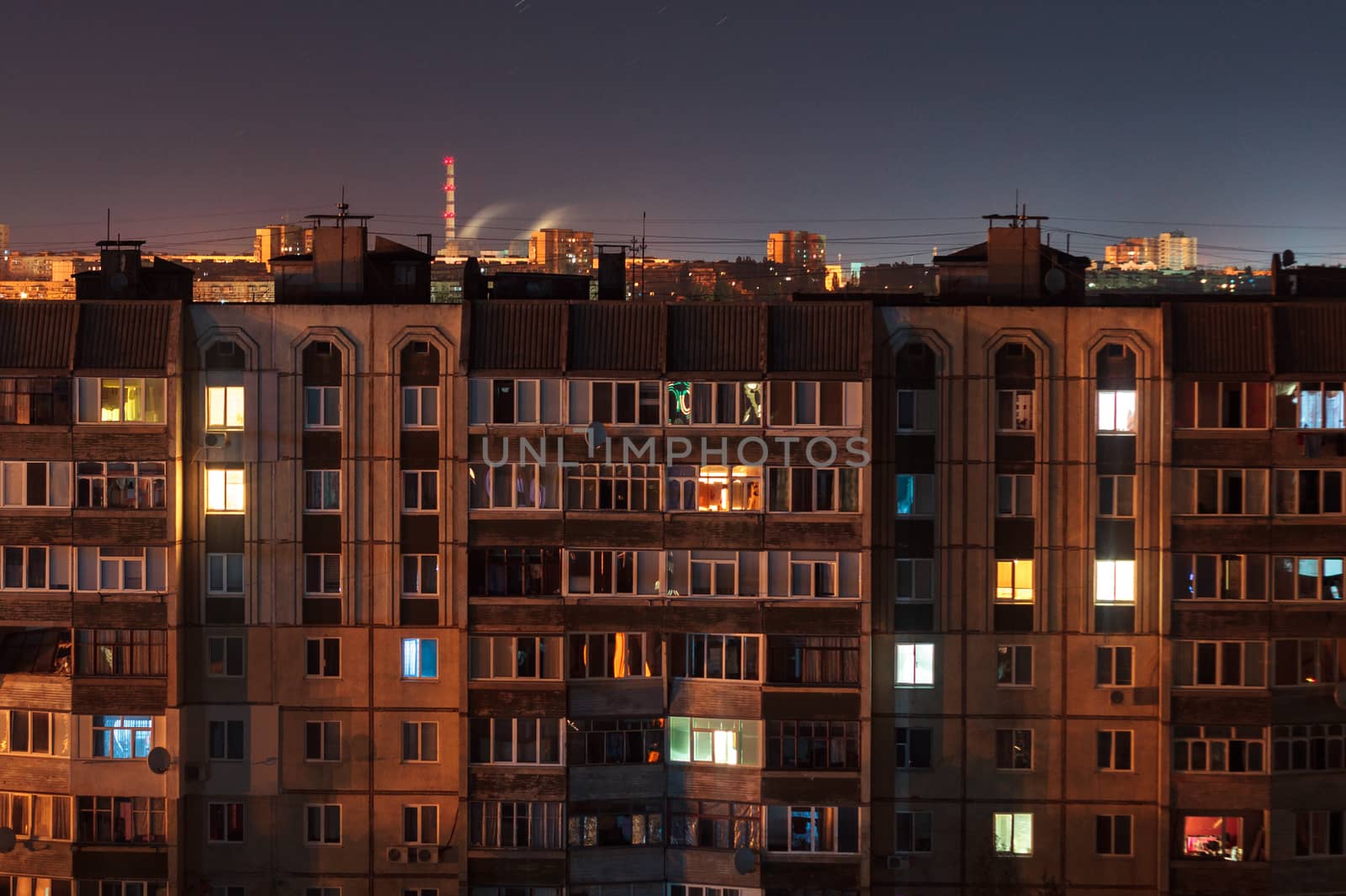 Night long exposure photo 9 and 10 floors high-rise buildings in orange colours. Big city life is here!