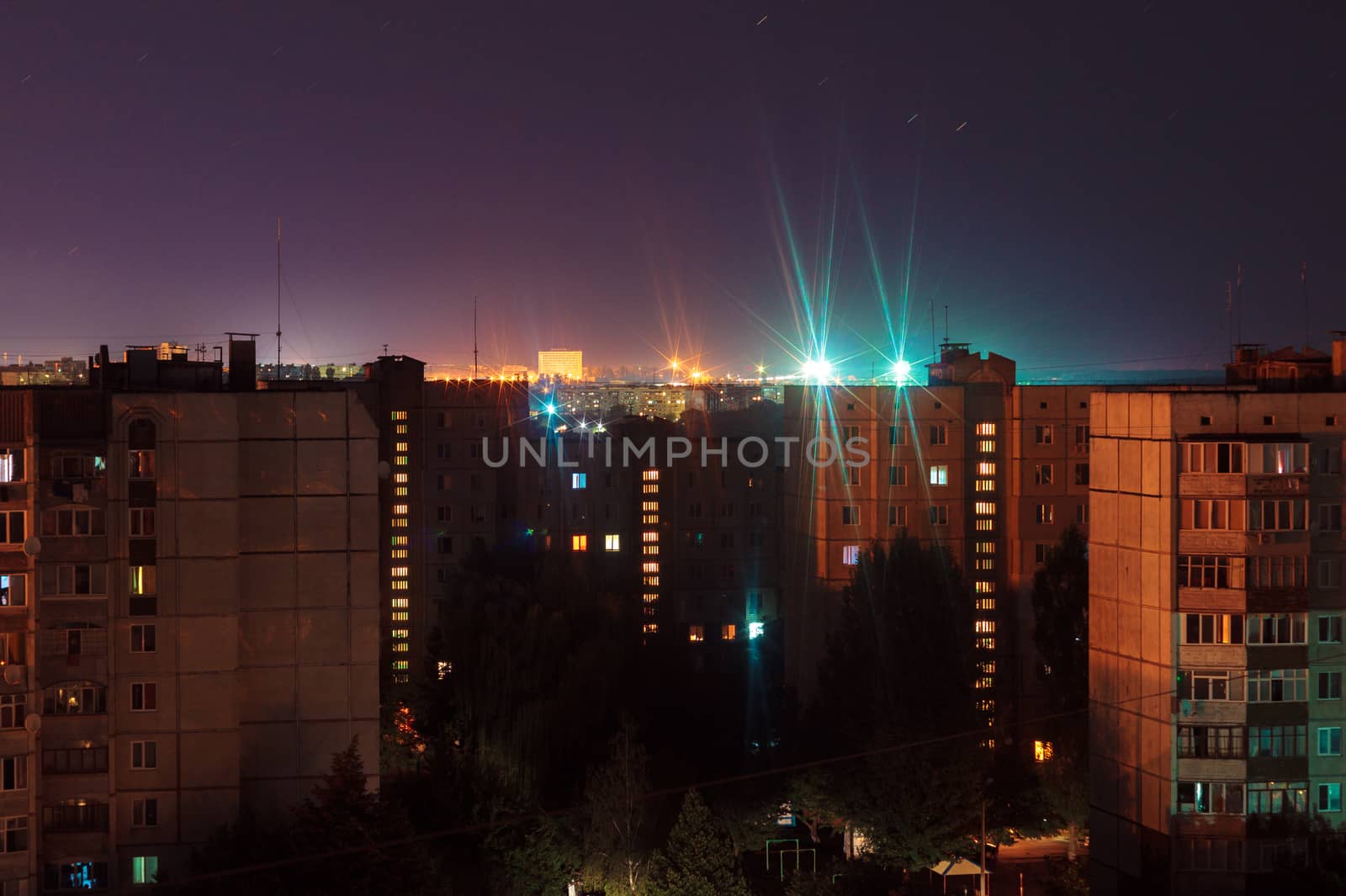 Night long exposure photo 9 and 10 floors high-rise buildings in orange and blue colours. Big city life is here!