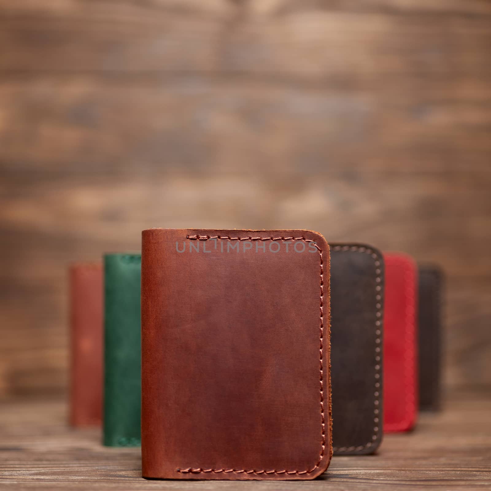 Soft focus photo of ginger colour handmade leather cardholder. Blurred background on photo. Different colour cardholders blurred on background.