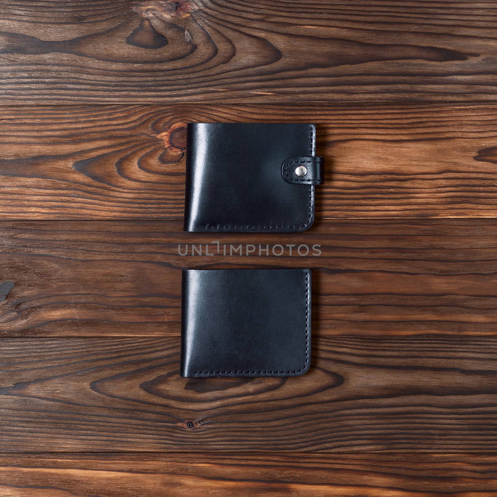 Blue handmade leather gloss wallets on wooden textured background. Up to down view. Businessman wallet stock photo.