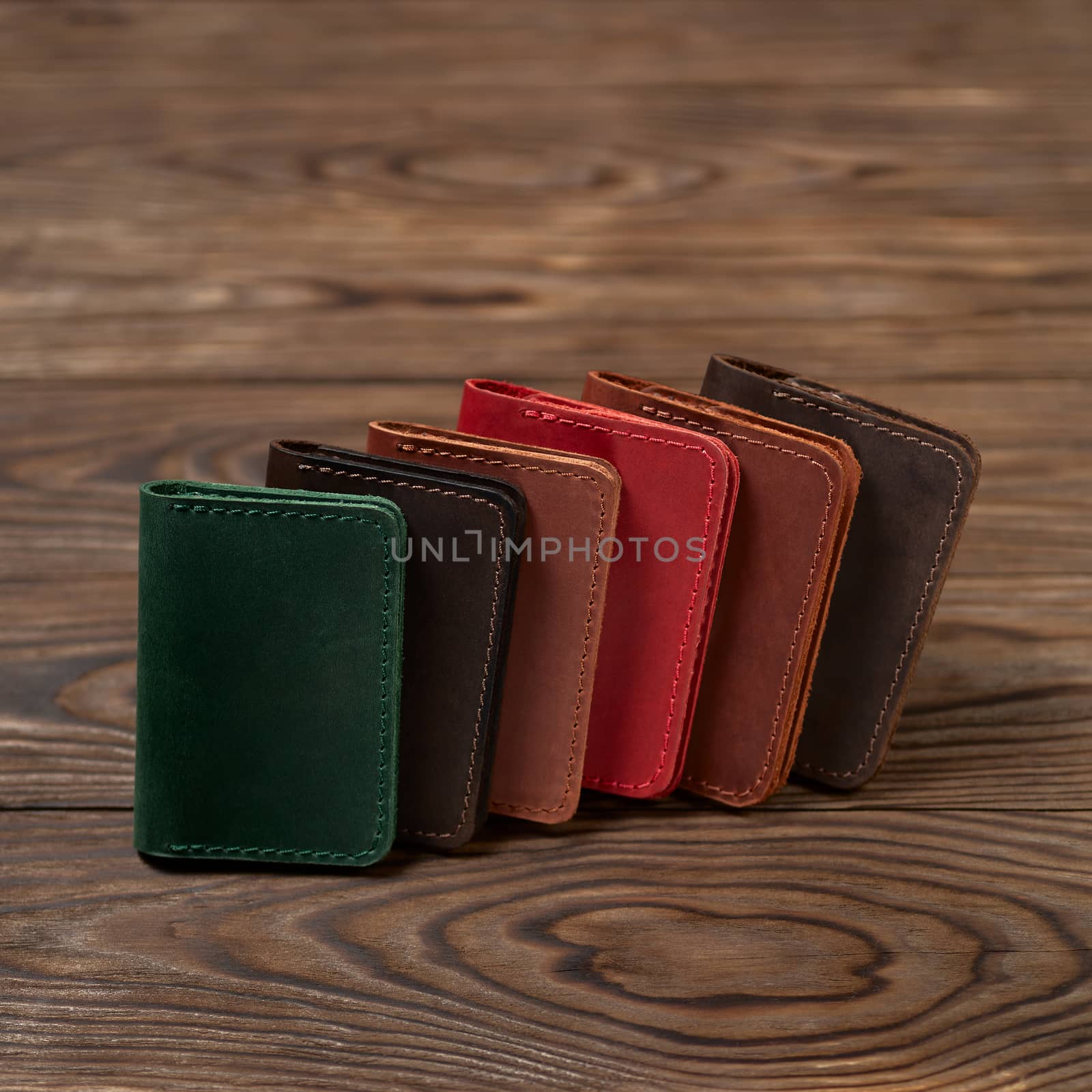 Six two-pocket leather handmade cardholder. Cardholders lies one on another. Stock photo on blurred background.