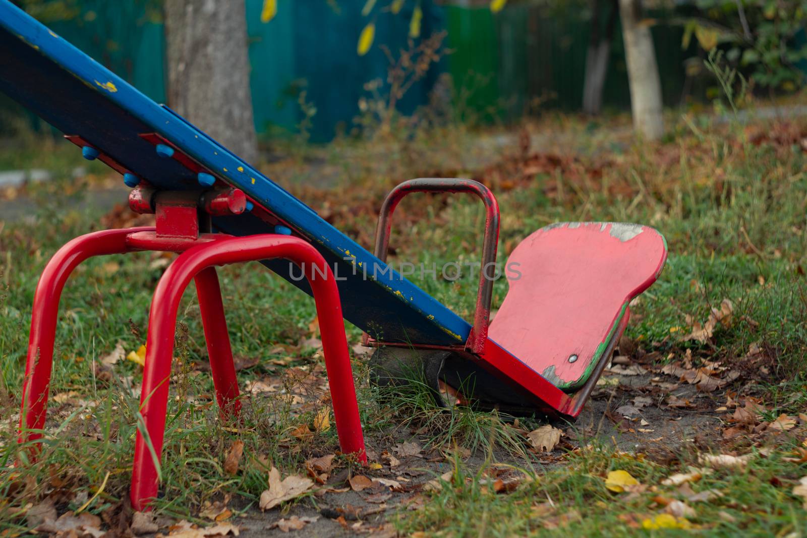 Baby swing in the fall in the park in wet weather