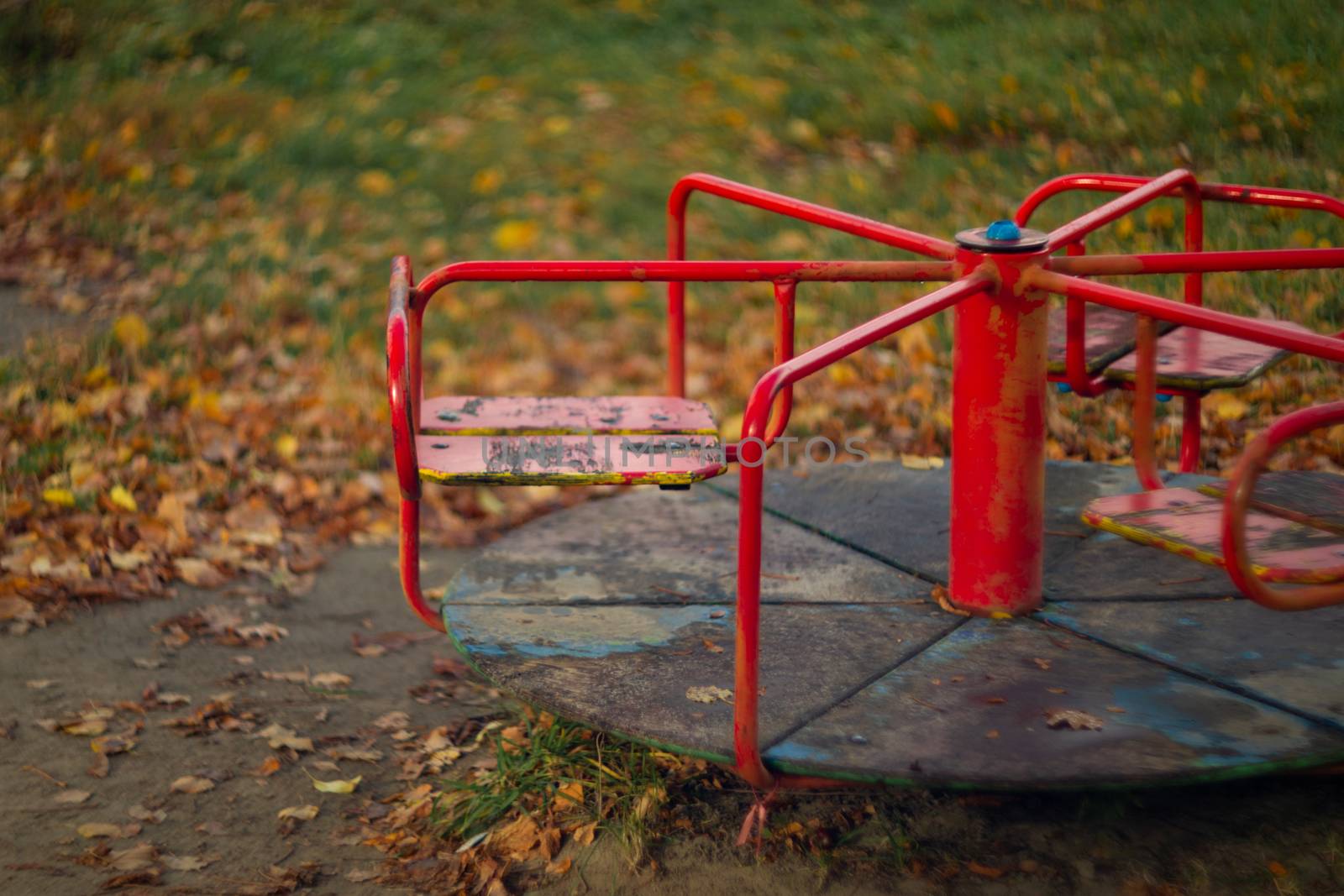 Baby swing in the fall in the park in wet weather