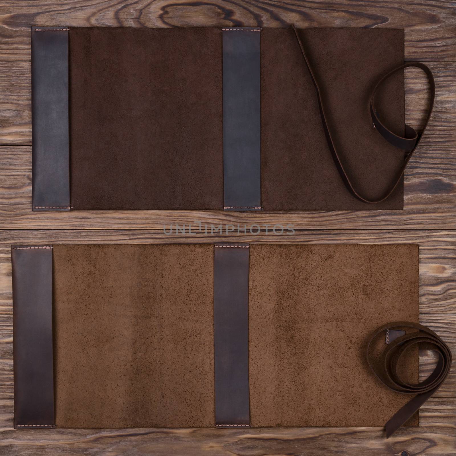 Two brown opened handmade leather notebook covers on wooden background. Stock photo of luxury business accessories.