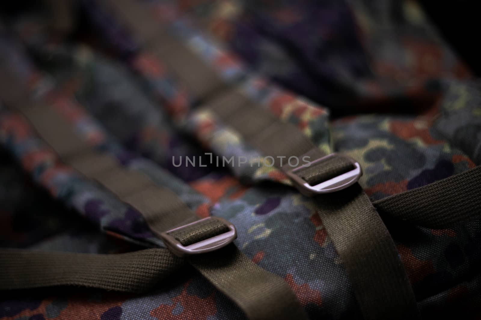 Military camouflage roomy backpack. In the frame of the strap and the back of a backpack. Close-up view.