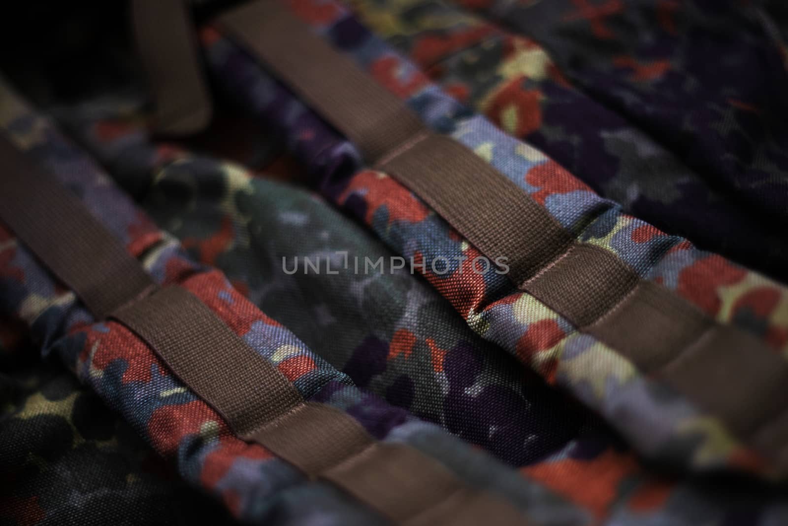 Military camouflage roomy backpack. In the frame of the strap and the back of a backpack. Close-up view.