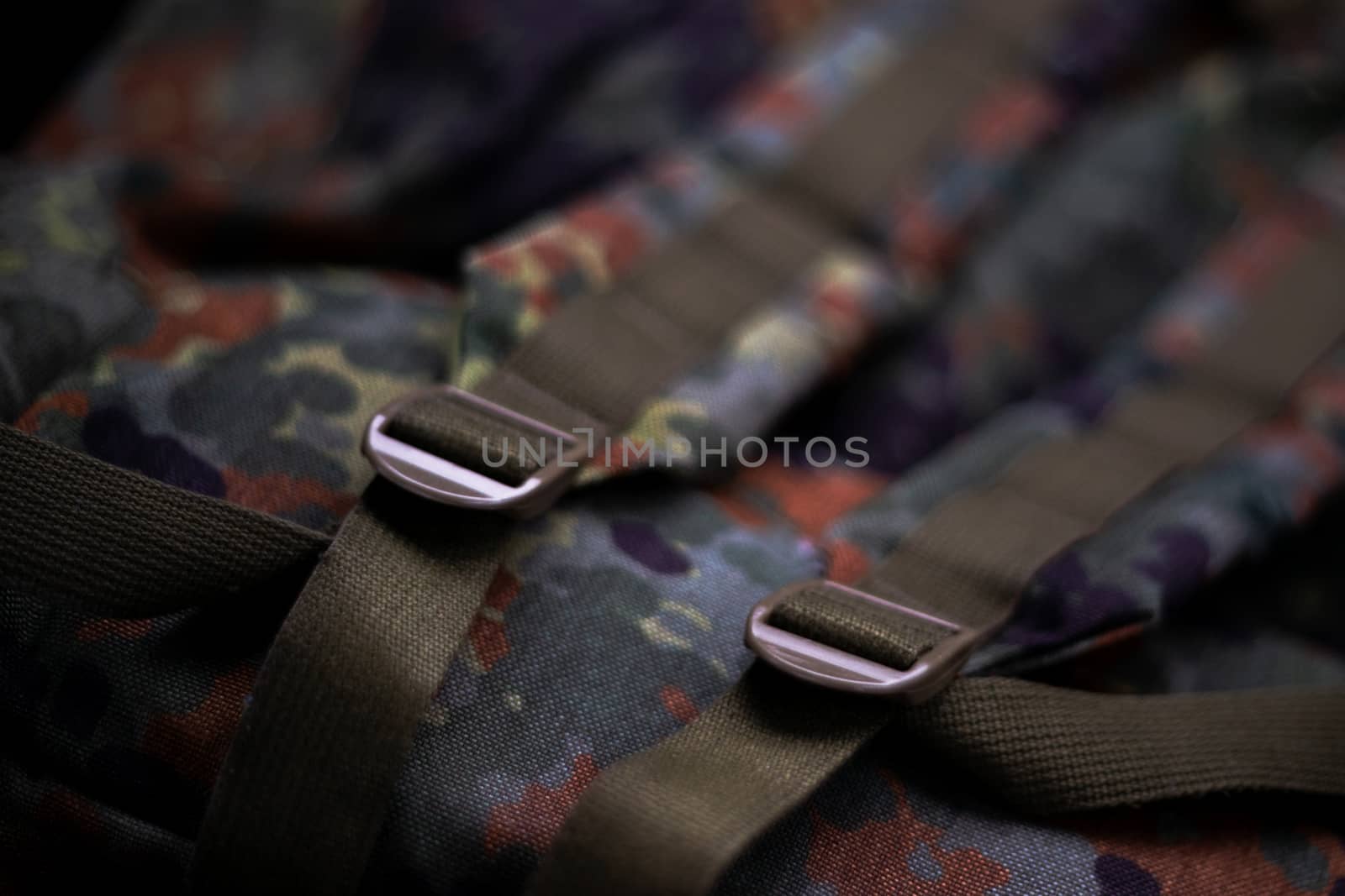Military camouflage roomy backpack. In the frame of the strap and the back of a backpack. Close-up view.
