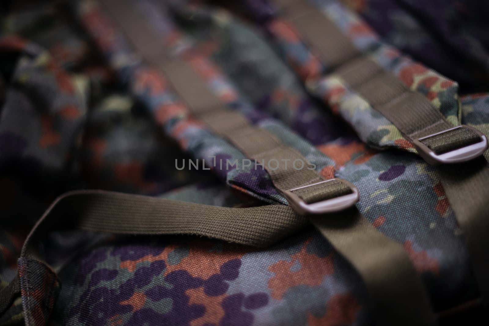 Military camouflage roomy backpack. In the frame of the strap and the back of a backpack. Close-up view.