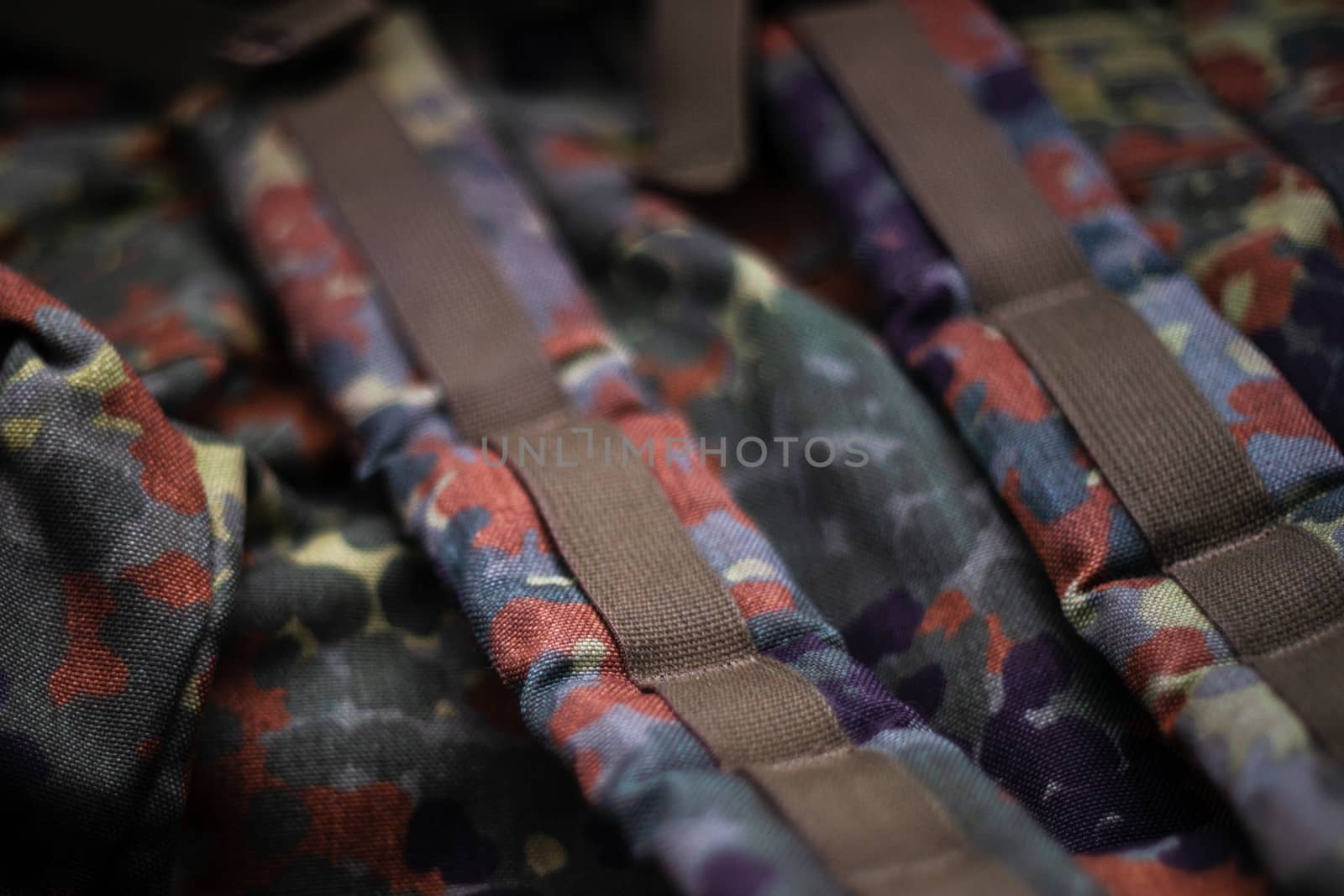 Military camouflage roomy backpack. In the frame of the strap and the back of a backpack. Close-up view.