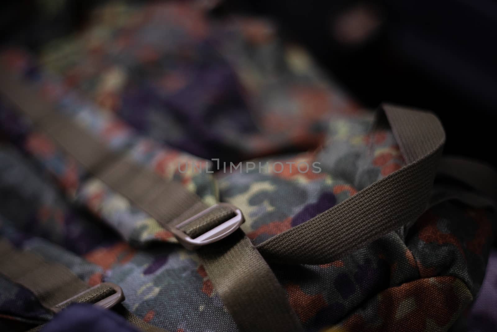 Military camouflage roomy backpack. In the frame of the strap and the back of a backpack. Close-up view.
